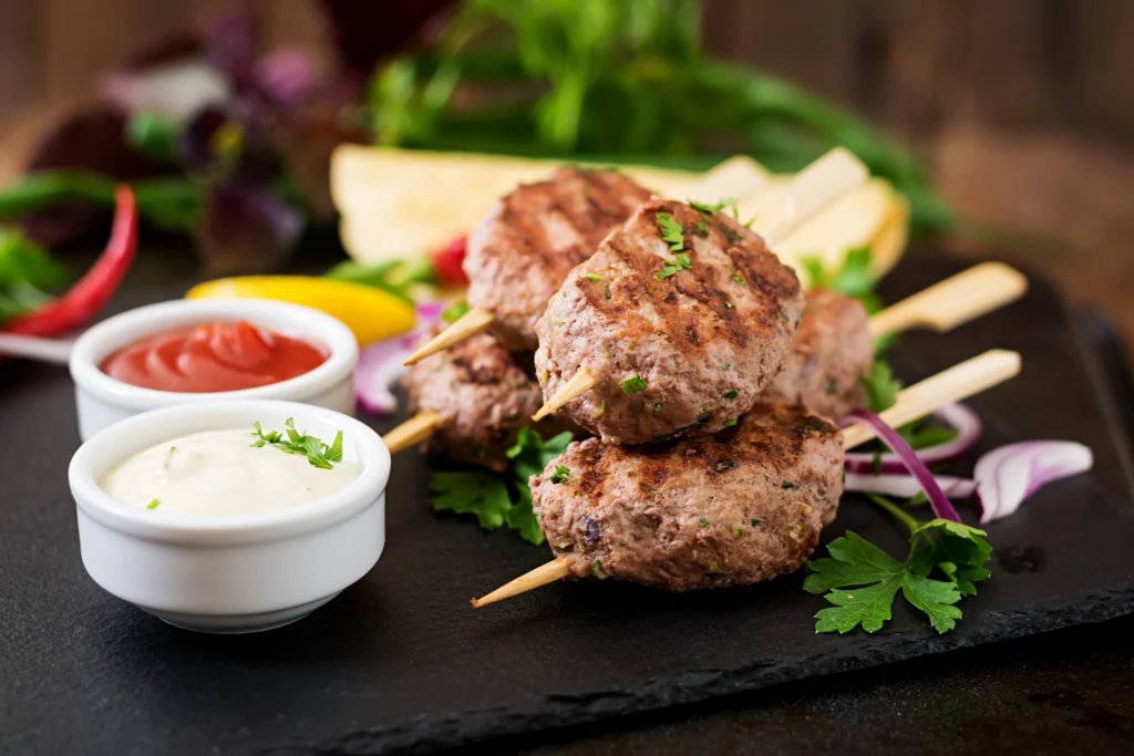 Spiced lamb koftas plated with creamy mint yogurt dip