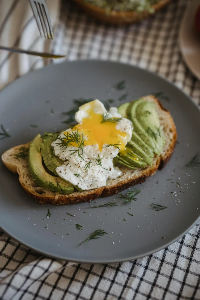 Avocado toast topped with a poached egg and chili flakes.