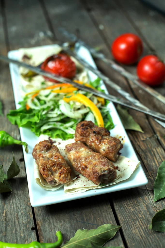 Grilled lamb koftas on skewers with a side of creamy mint yogurt.