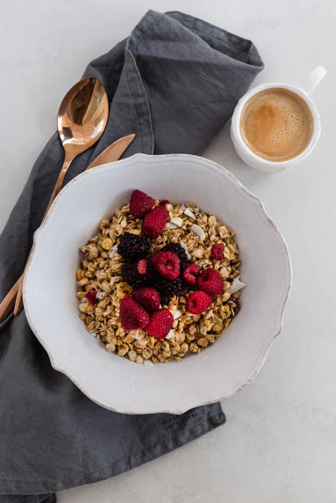 A bowl of creamy porridge topped with fresh berries, honey, and chia seeds.