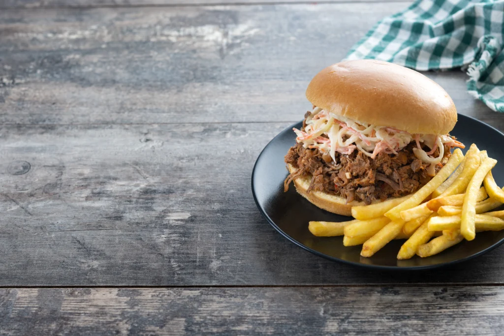 Smoky Sloppy Joes served on toasted brioche buns, with the rich meat sauce overflowing onto a wooden board